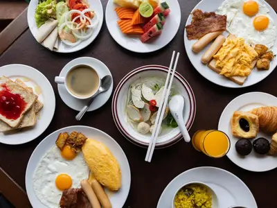 a table topped with plates of breakfast foods and coffee at Rembrandt Residences Bangkok in Bangkok