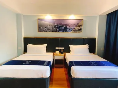 a hotel room with two beds and a picture on the wall at Sapphire Hotel Silom Bangkok in Bangkok