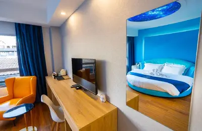 a hotel room with a bed and a mirror at Sapphire Hotel Silom Bangkok in Bangkok