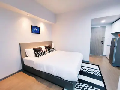 a bedroom with a large white bed with pillows on it at Star Sukhumvit in Bangkok