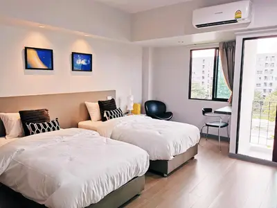 a hotel room with two beds and a couch at Star Sukhumvit in Bangkok