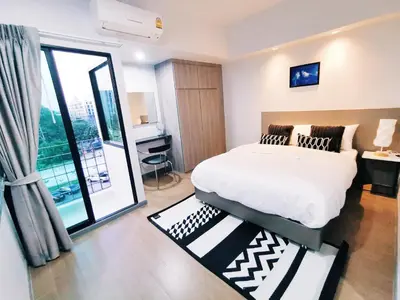 a bedroom with a bed and a large window at Star Sukhumvit in Bangkok