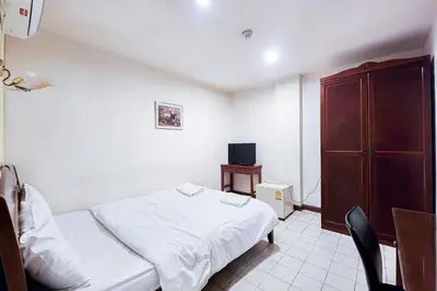 a small bedroom with a bed and a tv at Cordia Residence Sathorn in Bang Rak