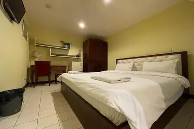 a bedroom with a large white bed and a desk at Cordia Residence Sathorn in Bang Rak