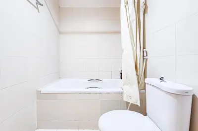 a bathroom with a toilet and a bath tub at Cordia Residence Sathorn in Bang Rak