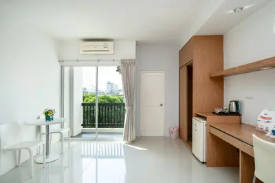 a kitchen with white walls and a large window at Riski Residence Ngamwongwan in Nonthaburi