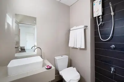 a bathroom with a toilet and a sink and a shower at Riski Residence Ngamwongwan in Nonthaburi