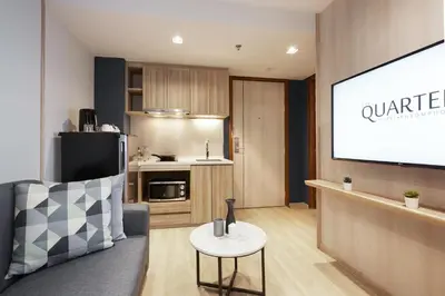 a living room with a tv and a couch and a table at The Quarter Phromphong by UHG in Bangkok