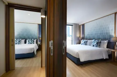 a hotel room with two beds and a window at The Quarter Phromphong by UHG in Bangkok