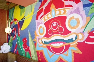 a wall with a colorful face painted on it at 4 Monkeys Hotel in Bangkok