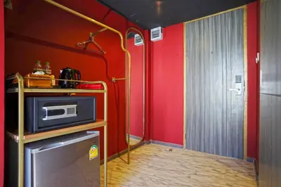 a kitchen with red walls and a microwave on a counter at 4 Monkeys Hotel in Bangkok
