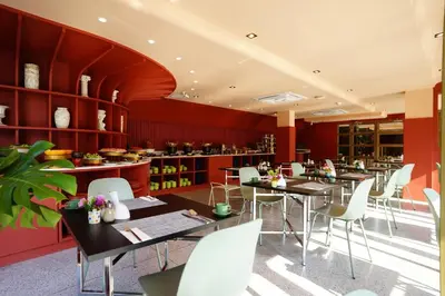a dining room with tables and white chairs at 4 Monkeys Hotel in Bangkok
