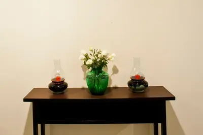 a table with a green vase with flowers in it at G9bangkok in Bangkok