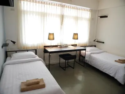 two beds in a room with a desk and a desk at G9bangkok in Bangkok