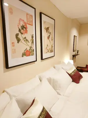 a white couch in a room with pictures on the wall at Real Bangkok Guesthouse Private 3BR Home 3 Min to BTS Ratchathewi in Bangkok