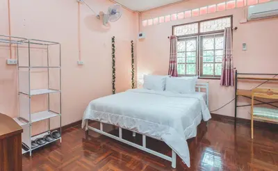 a bedroom with a white bed and a window at Gaiwandhanat Homestay in Bangkok