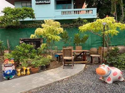a garden with a table and chairs and plants at Gaiwandhanat Homestay in Bangkok