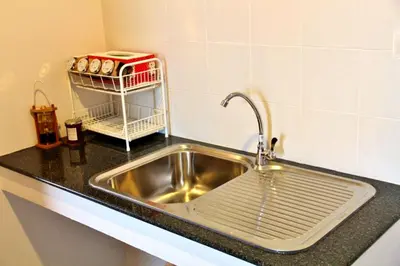 a kitchen counter with a sink and a shelf at The Meet Green Apartment in Bangkok