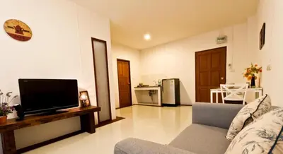 a living room with a couch and a flat screen tv at The Meet Green Apartment in Bangkok