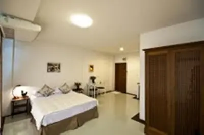 a bedroom with a bed and a living room at The Meet Green Apartment in Bangkok