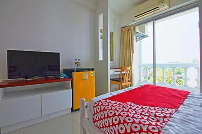 a bedroom with a tv and a bed with a red blanket at Super OYO 498 Ladawan Villa in Bangkok