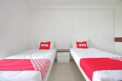 two beds in a room with red and white sheets at Super OYO 498 Ladawan Villa in Bangkok