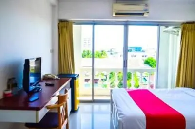 a bedroom with a desk and a bed and a window at Super OYO 498 Ladawan Villa in Bangkok