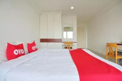 a bedroom with a large bed with red pillows at Super OYO 498 Ladawan Villa in Bangkok
