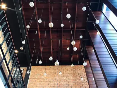 a bunch of lights hanging from a ceiling at The LOCAL Ari in Bangkok