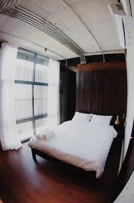 a bed in a room with a large window at The LOCAL Ari in Bangkok