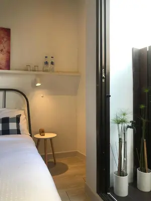 a bedroom with a bed and a window with plants at UHU Bangkok in Bangkok