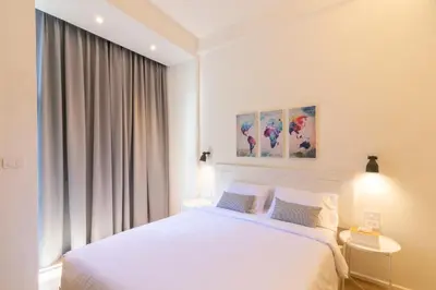 a bedroom with a white bed and a window at UHU Bangkok in Bangkok