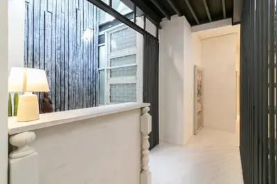 a hallway with a window and a table with a lamp at UHU Bangkok in Bangkok