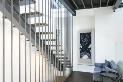 a spiral staircase in a living room with a blue couch at UHU Bangkok in Bangkok