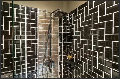 a bathroom with a shower with a mosaic tile wall at The Matta in Bangkok