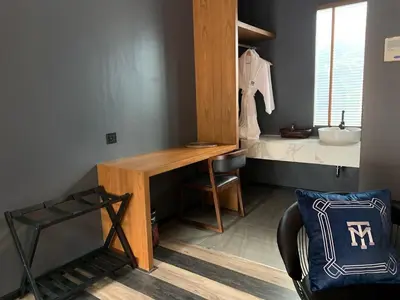 a bathroom with a desk and a sink in a room at The Matta in Bangkok