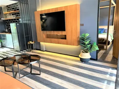 a living room with a tv and a coffee table at The Matta in Bangkok