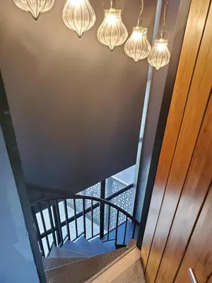 an overhead view of a staircase with chandeliers at The Matta in Bangkok