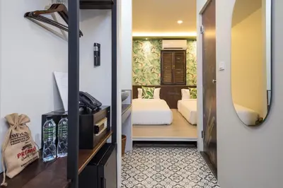 a room with a bedroom with a bed and a mirror at FOODOTEL in Bangkok