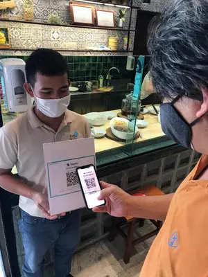 a man wearing a mask holding a box at FOODOTEL in Bangkok