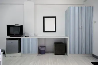 a room with a tv and a desk with a mirror at Sakun Place in Bangna