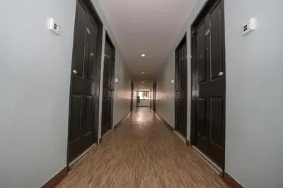 a hallway with dark wood doors and a long corridor at Sakun Place in Bangna
