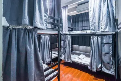 two bunk beds in a room with curtains at Ali Hostel in Bangkok