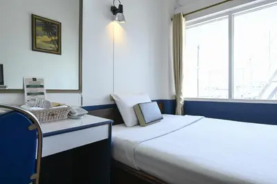a bedroom with a large bed and a window at The Krungkasem Srikrung Hotel in Bangkok