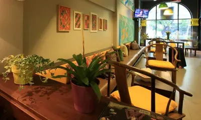 a living room with a couch and some plants at S1hostel Bangkok in Bangkok