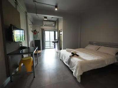 a bedroom with a bed and a desk and a television at S1hostel Bangkok in Bangkok