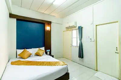 a bedroom with a large bed with a blue headboard at Riski Residence Bangkok-noi - Wasit Apartment in Bangkok