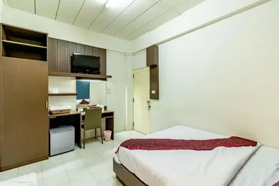 a bedroom with a bed and a desk with a computer at Riski Residence Bangkok-noi - Wasit Apartment in Bangkok