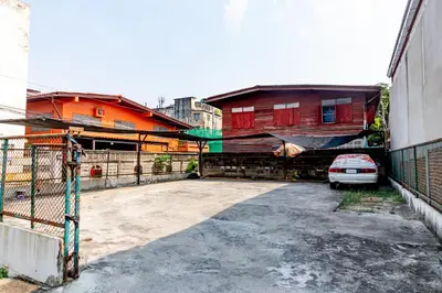 a car parked in a parking lot next to buildings at Riski Residence Bangkok-noi - Wasit Apartment in Bangkok
