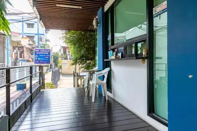 a porch of a restaurant with a table and a window at Riski Residence Bangkok-noi - Wasit Apartment in Bangkok